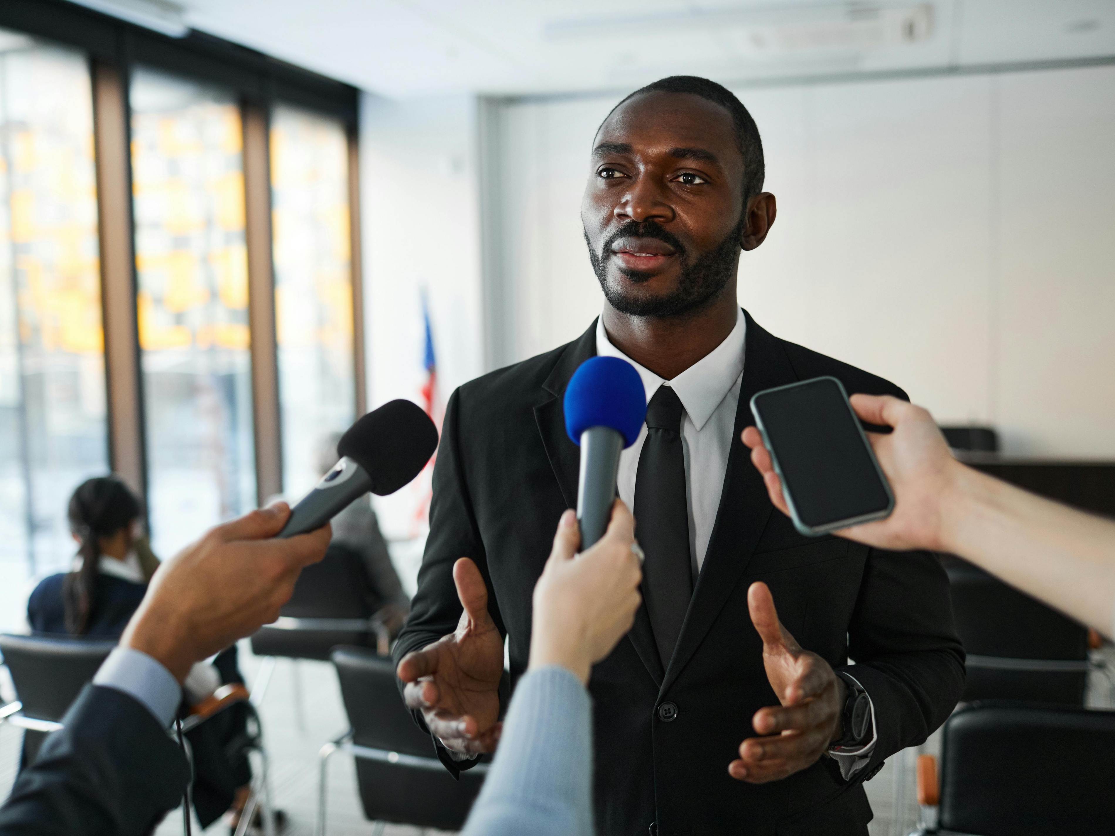 A student in a classroom talks while two other students look at her.